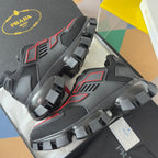 Prada unisex sneakers side view, dark panels with red details and thick lug outsole