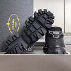 Prada unisex sneaker bottom view, black rugged tread sole with brand heel label