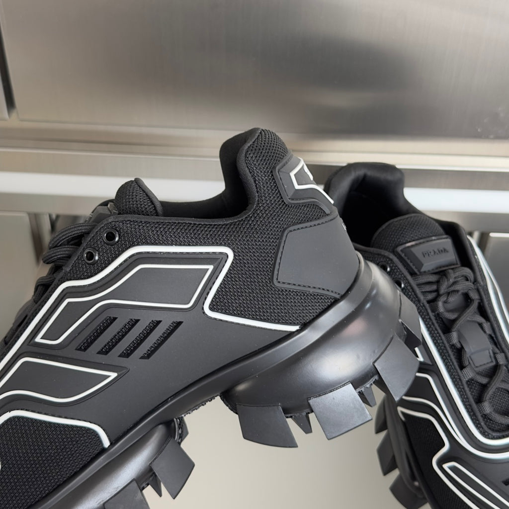Prada unisex sneaker close-up, black upper with white trim and chunky lug heel