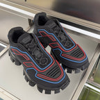Prada unisex sneakers pair on display, dark uppers with blue and red patterned trim