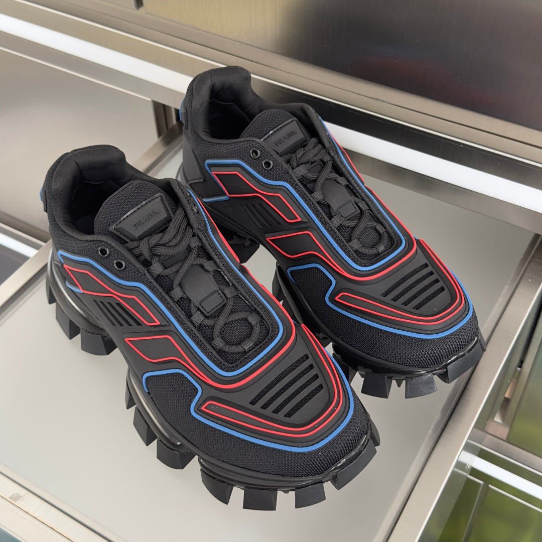 Prada unisex sneakers pair on display, dark uppers with blue and red patterned trim
