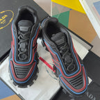 Prada unisex lace-up sneakers with dark knit uppers and blue/red trim, chunky outsole