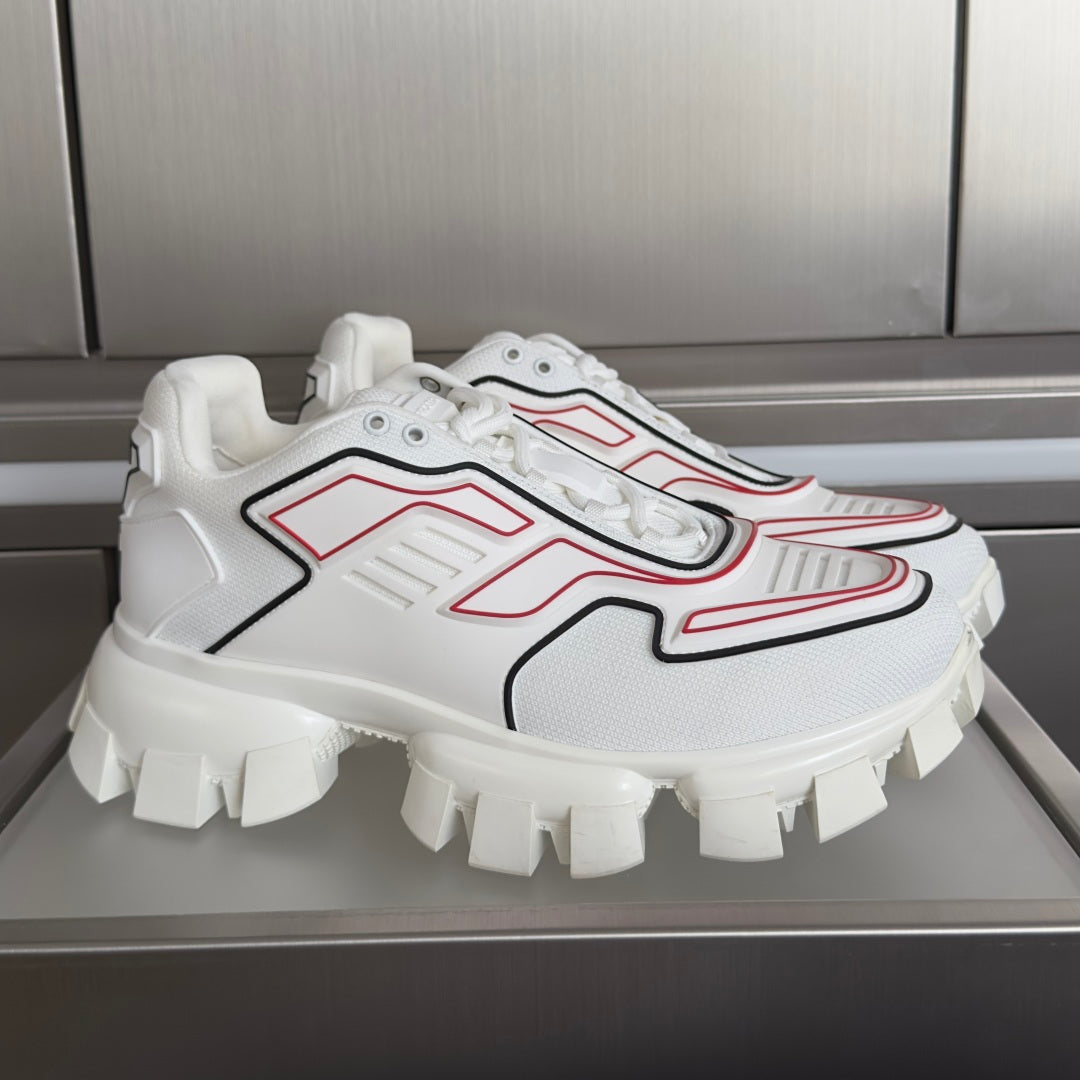 White unisex sneakers with red and black panel detailing and chunky platform sole