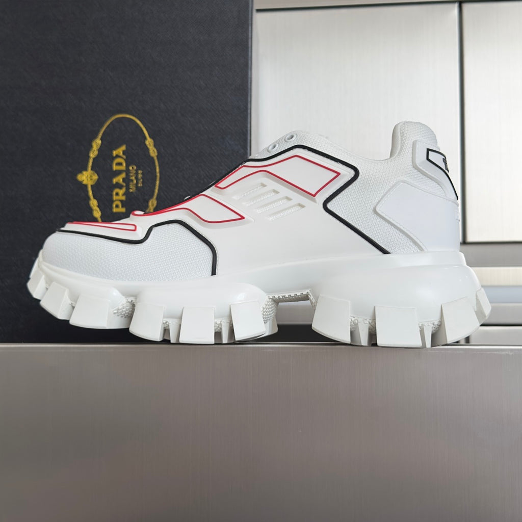 White unisex sneakers with red and black accents and thick treaded outsole