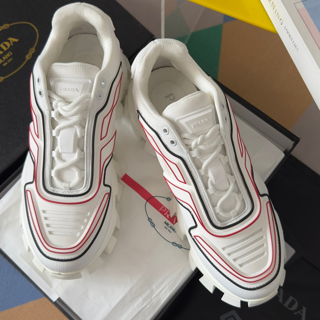 White unisex sneakers with lace-up front, red and black piping, and padded collar