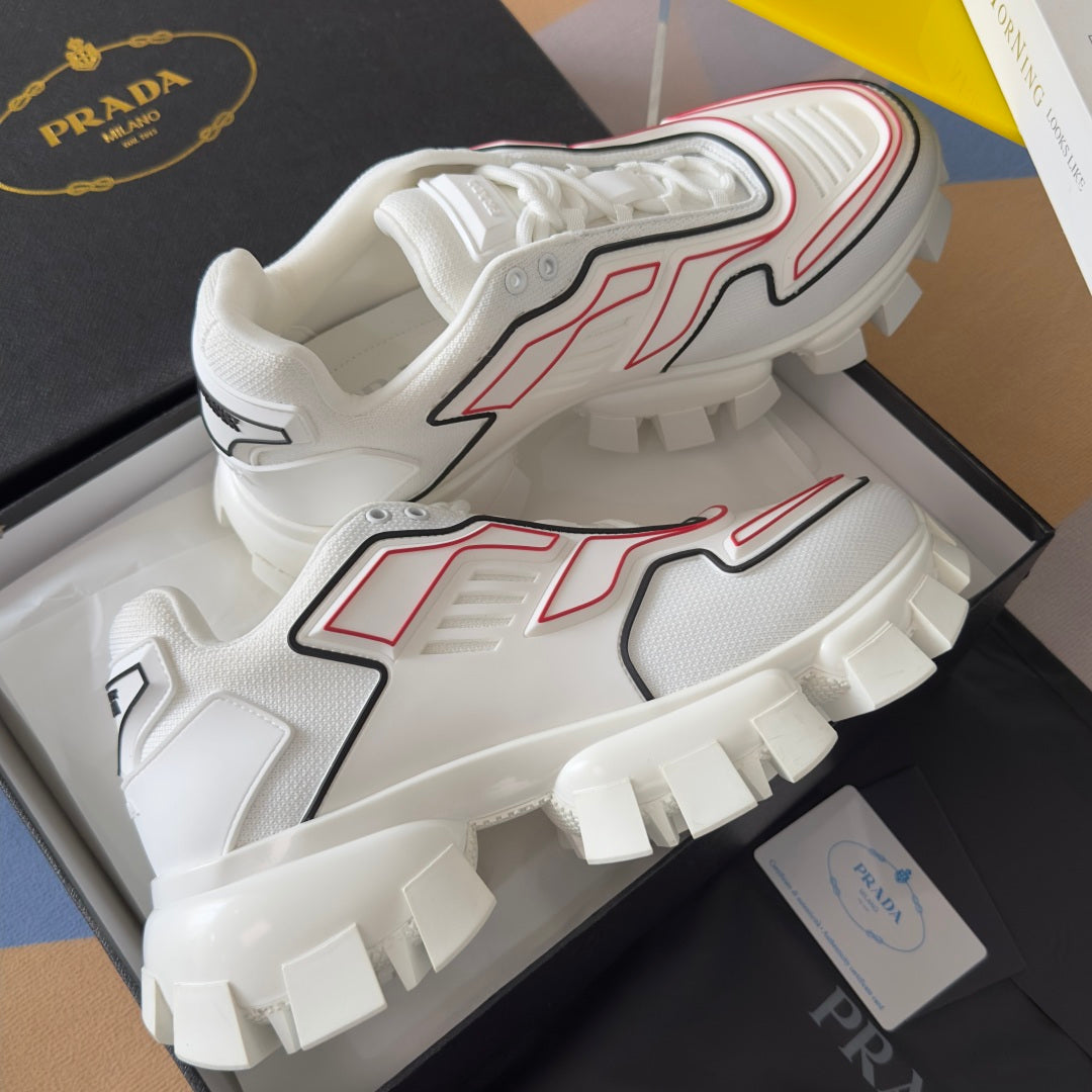 White unisex sneakers with red and black trim, chunky lug sole and lace-up front