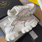 White chunky sneakers with red and black geometric detailing and raised tread sole