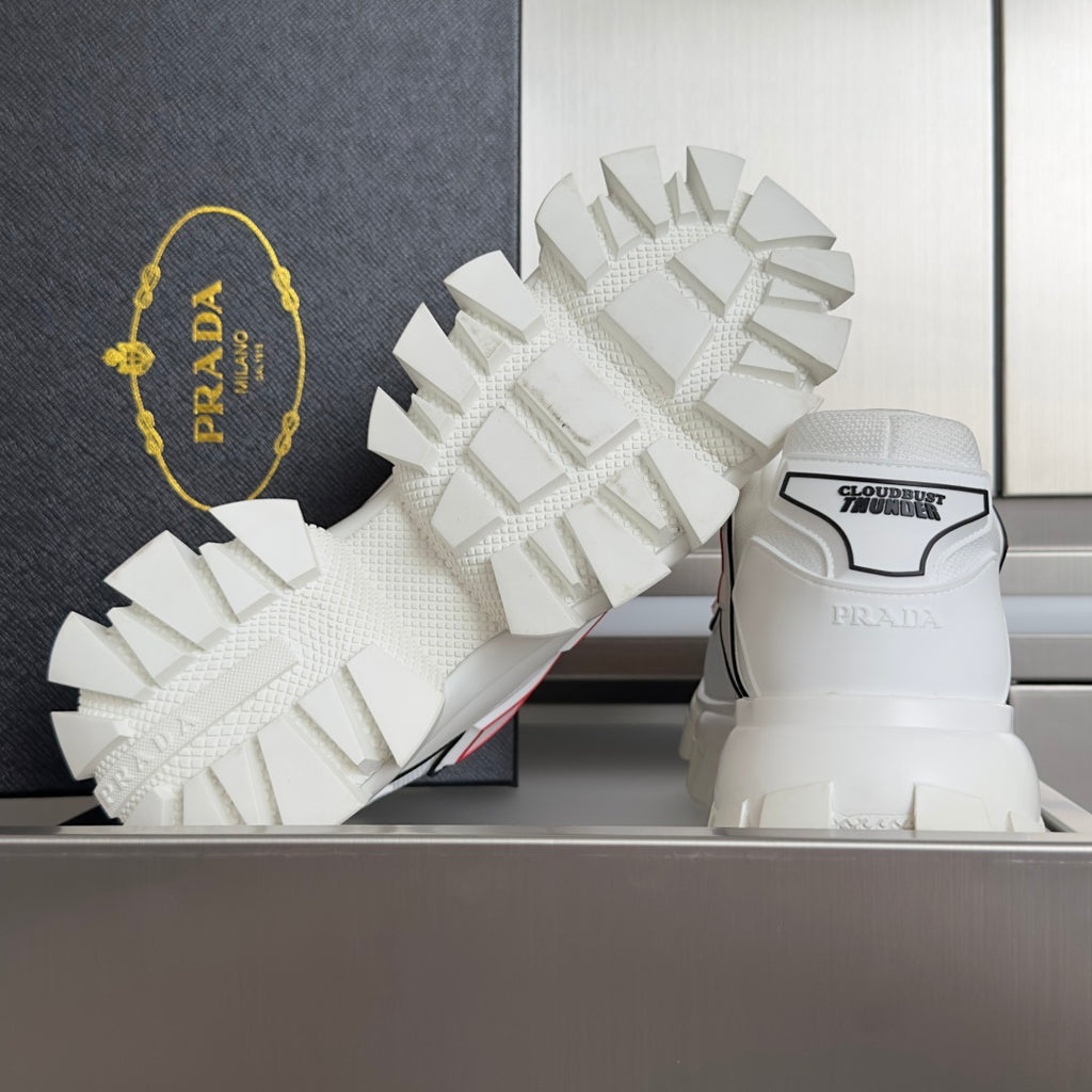 White unisex sneakers with detailed tread pattern on chunky outsole and heel text