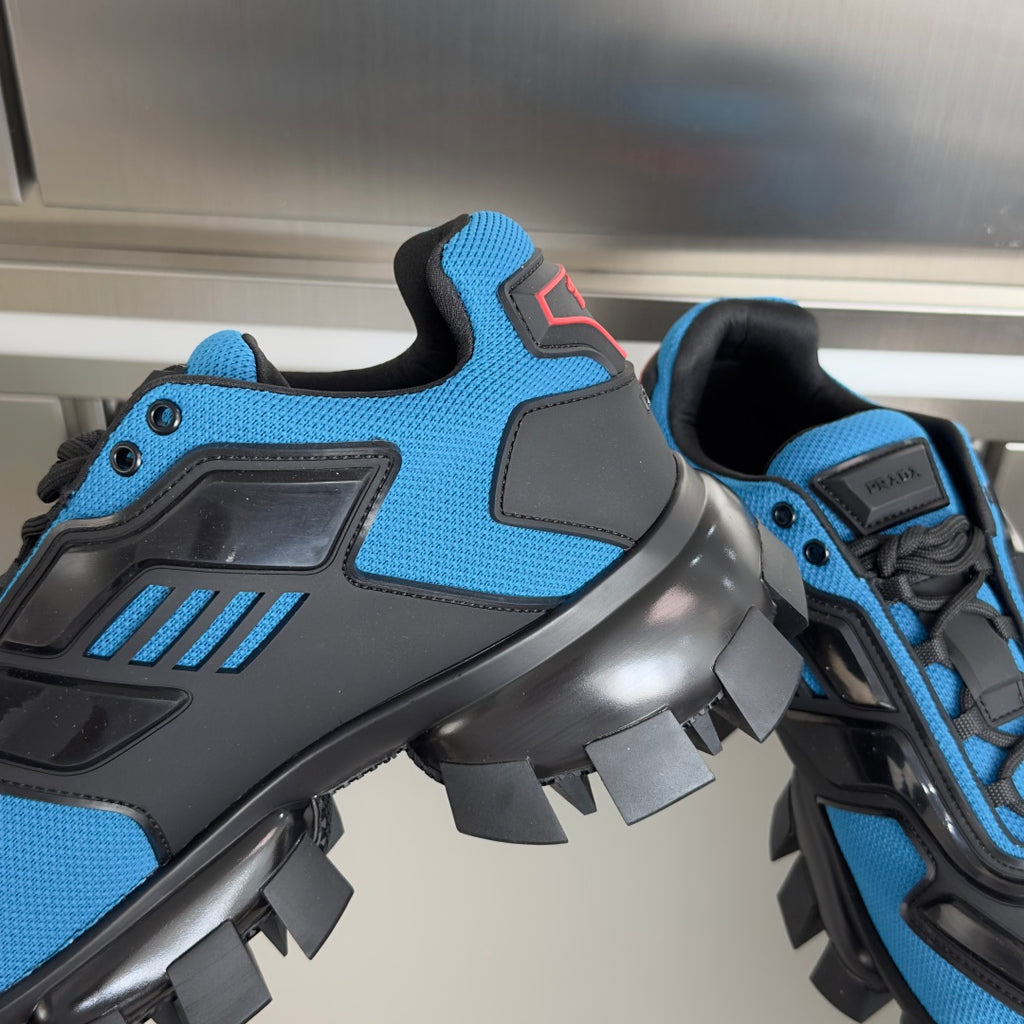 Blue and black unisex Prada sneakers close-up with bold panels and lug traction