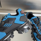 Blue and black unisex Prada sneakers close-up with bold panels and lug traction