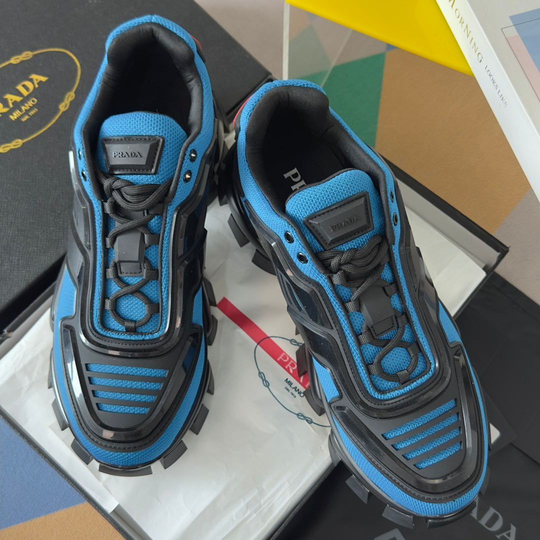 Blue and black unisex Prada sneakers with logo patch on tongue and lace-up style