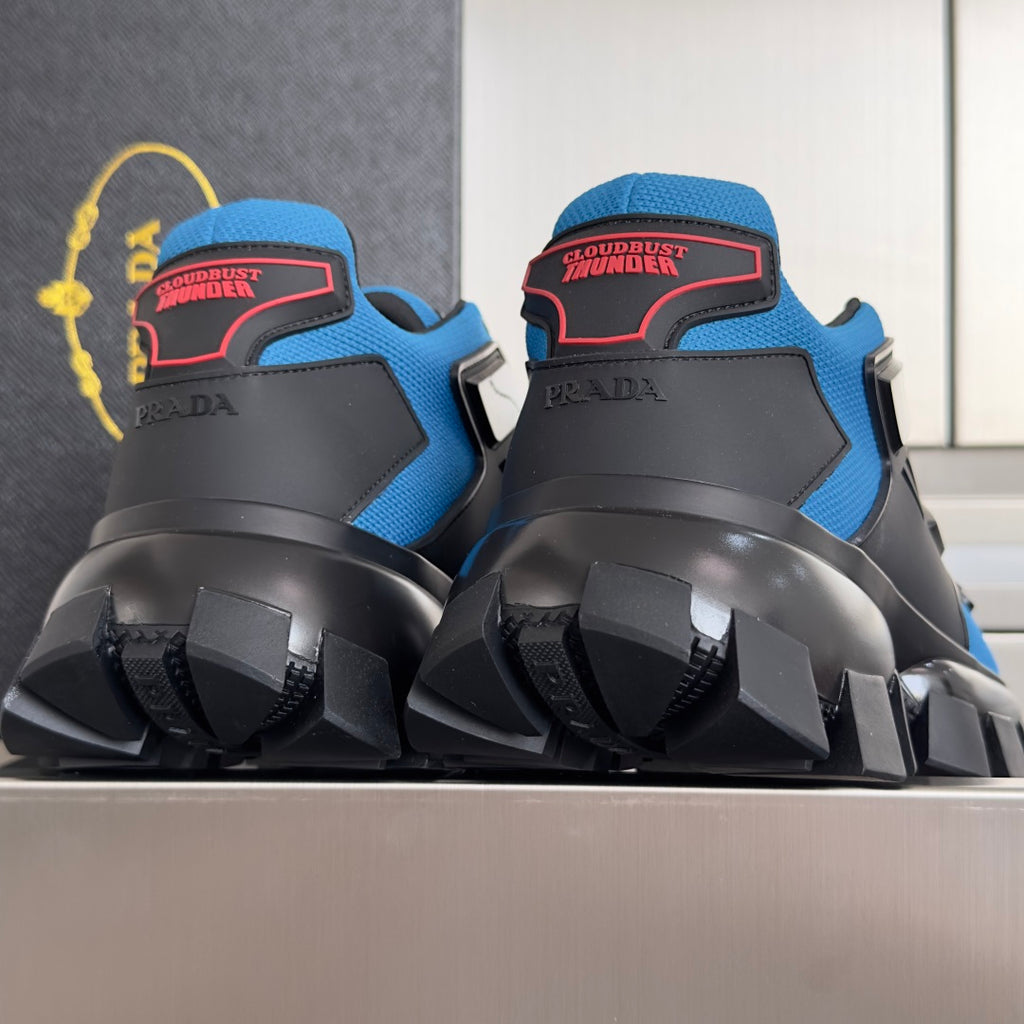 Blue and black unisex Prada sneakers with rear heel logo and thick lug outsole