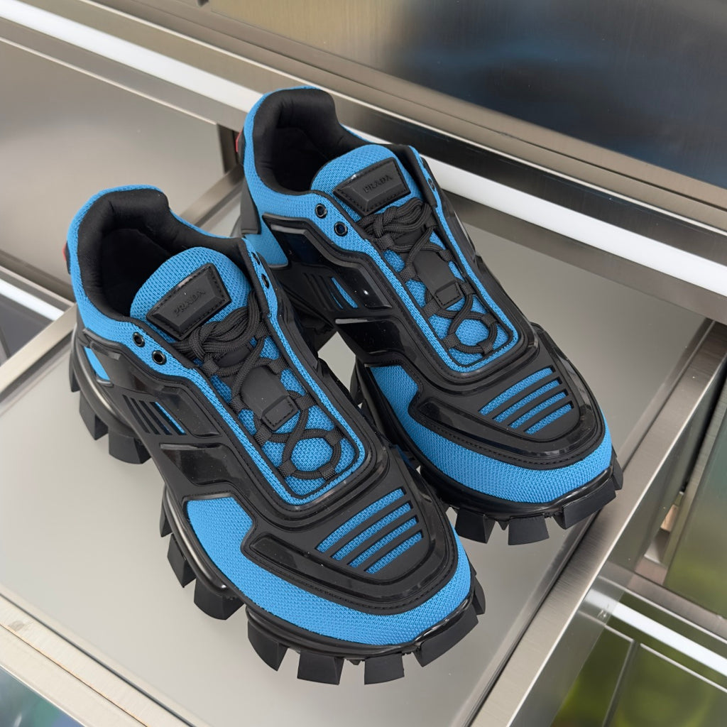 Pair of blue and black unisex Prada sneakers with rugged lug outsole and laces