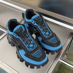 Pair of blue and black unisex Prada sneakers with rugged lug outsole and laces