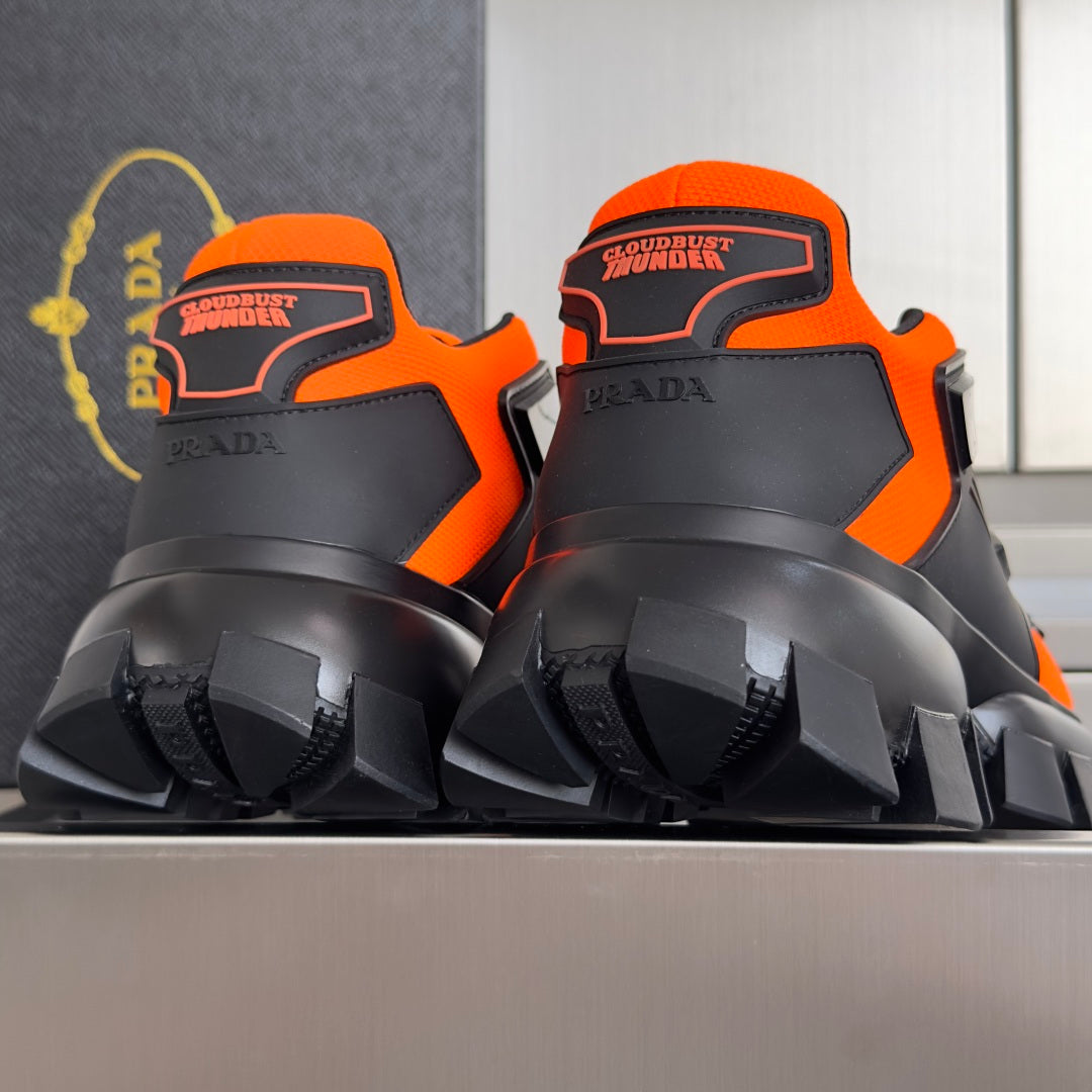 Unisex chunky sneakers close-up at heel, orange and black with high lug tread