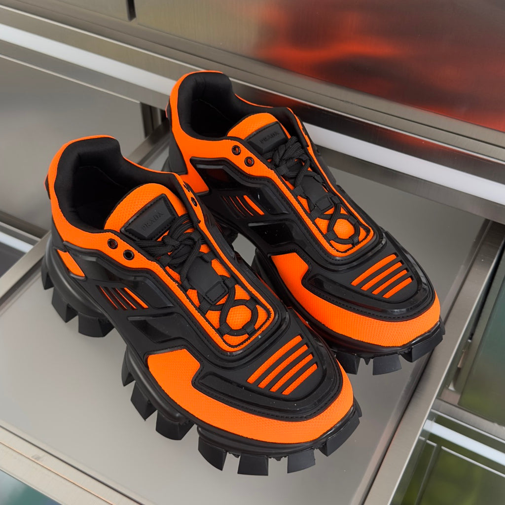 Prada unisex sneakers, orange and black, lace-up high-top with rugged cleats.