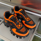 Prada unisex sneakers, orange and black, lace-up high-top with rugged cleats.