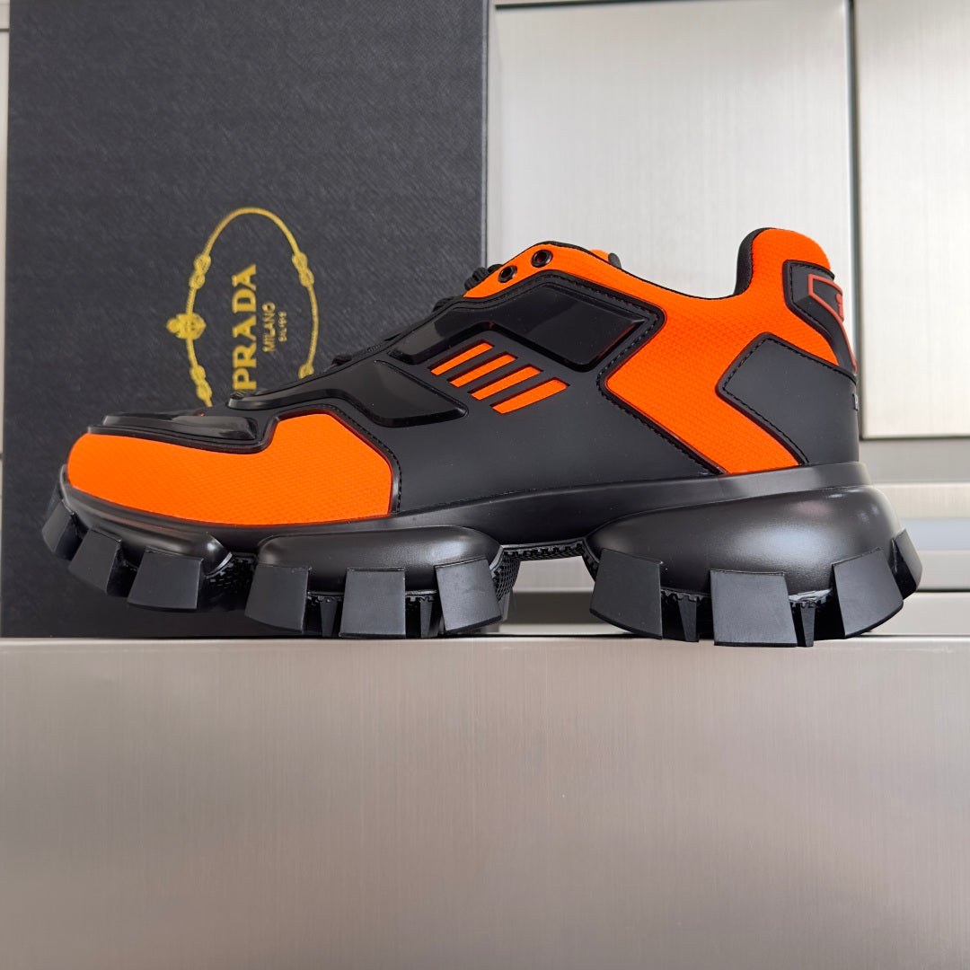 Unisex chunky sneakers, side view, orange accents on black upper with treaded sole