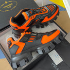 Prada unisex sneakers, orange and black, lace-up high-top with thick lug soles.