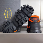 Prada unisex sneaker, black outsole tread detail with orange heel accents.