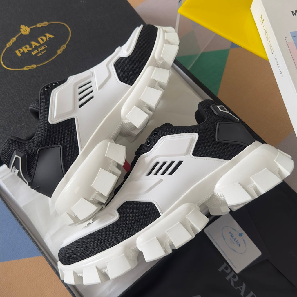 Prada unisex sneakers angled view, black and white uppers with thick raised tread sole