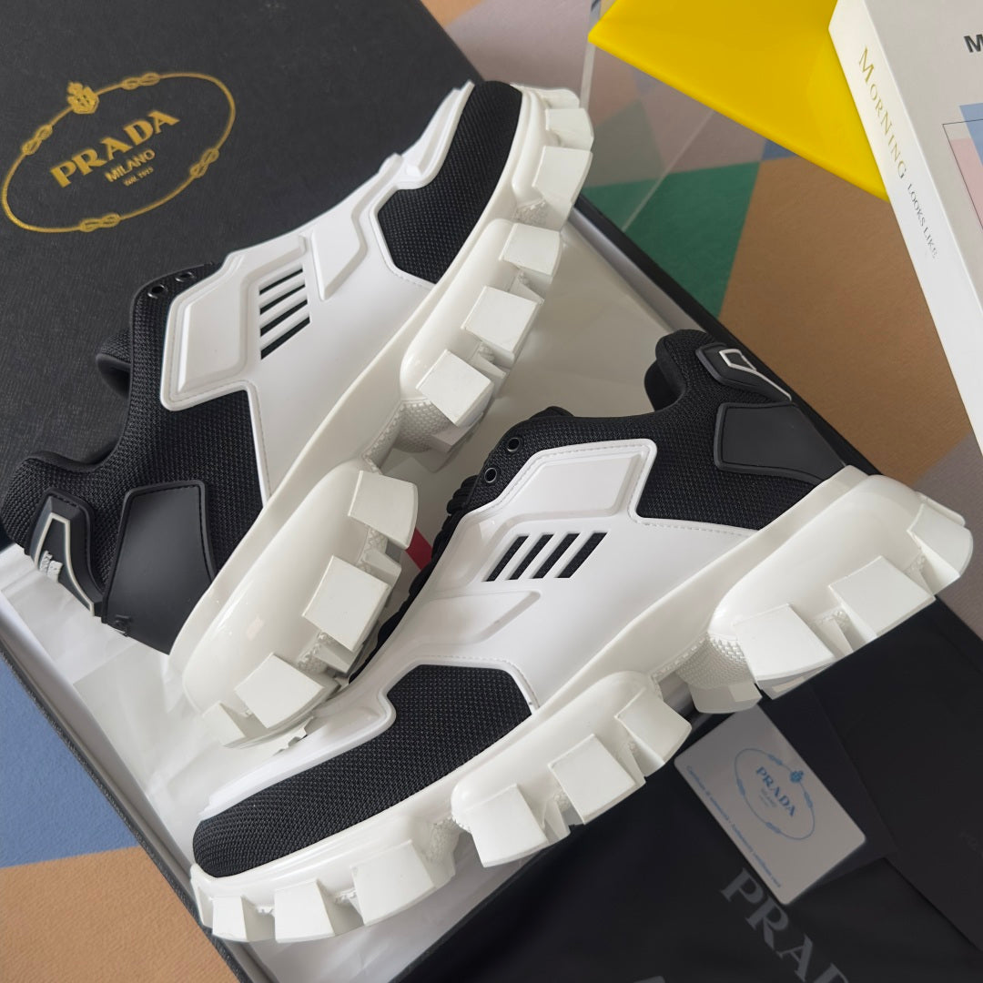Prada unisex sneakers angled view, black and white uppers with thick raised tread sole