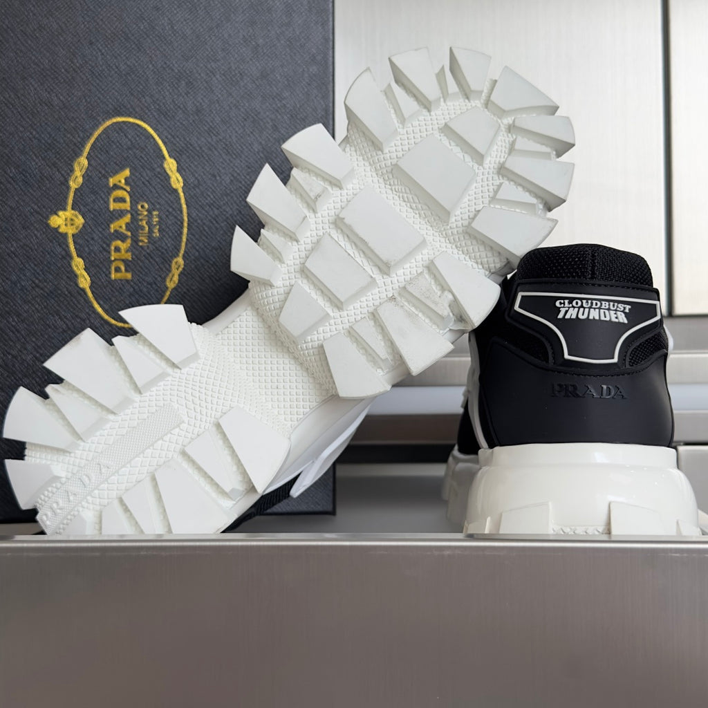 Black and white sneakers with white treaded outsole and rear heel logo panel