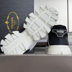 Black and white sneakers with white treaded outsole and rear heel logo panel