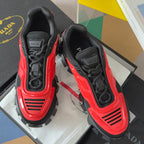Prada unisex sneakers, black uppers with red side accents, lace-up design.