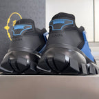 Back view of dark sneakers with blue accents, padded heel, and thick lug sole