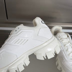 White sneaker side view with thick lug outsole and small logo patch