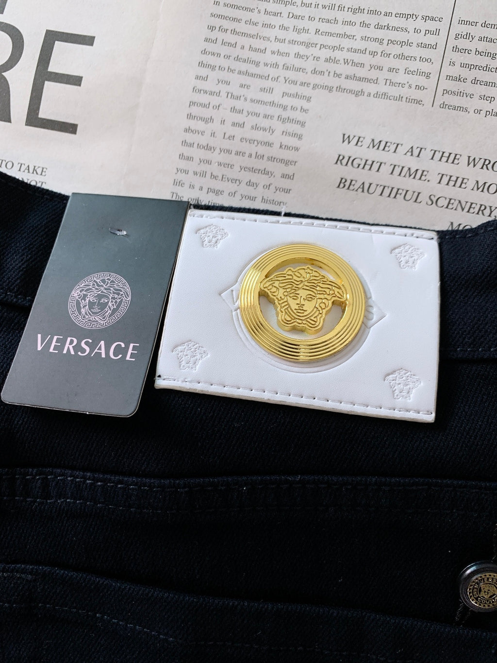 Dark denim jeans with leather patch showing Versace Medusa logo