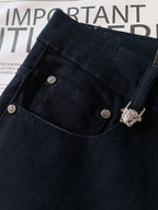 Dark denim jeans pocket with metal buttons and decorative lion hardware