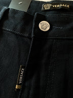 Black denim jeans with Versace label and round engraved button
