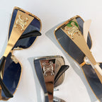 Celine sunglasses close-up: gold frame with ornate emblem and dark tinted lenses