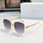 Dior sunglasses with gold frame and dark purple gradient lenses, square cat-eye style