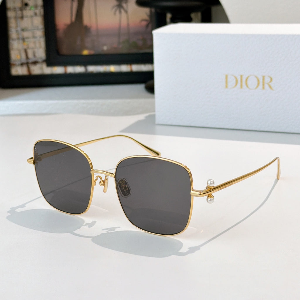 Dior sunglasses with gold frame and dark gray gradient lenses, rounded square cat-eye style