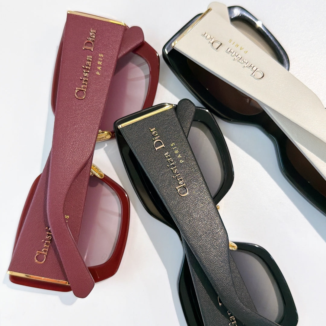 Dior glasses display with maroon and black cases and a gray frame