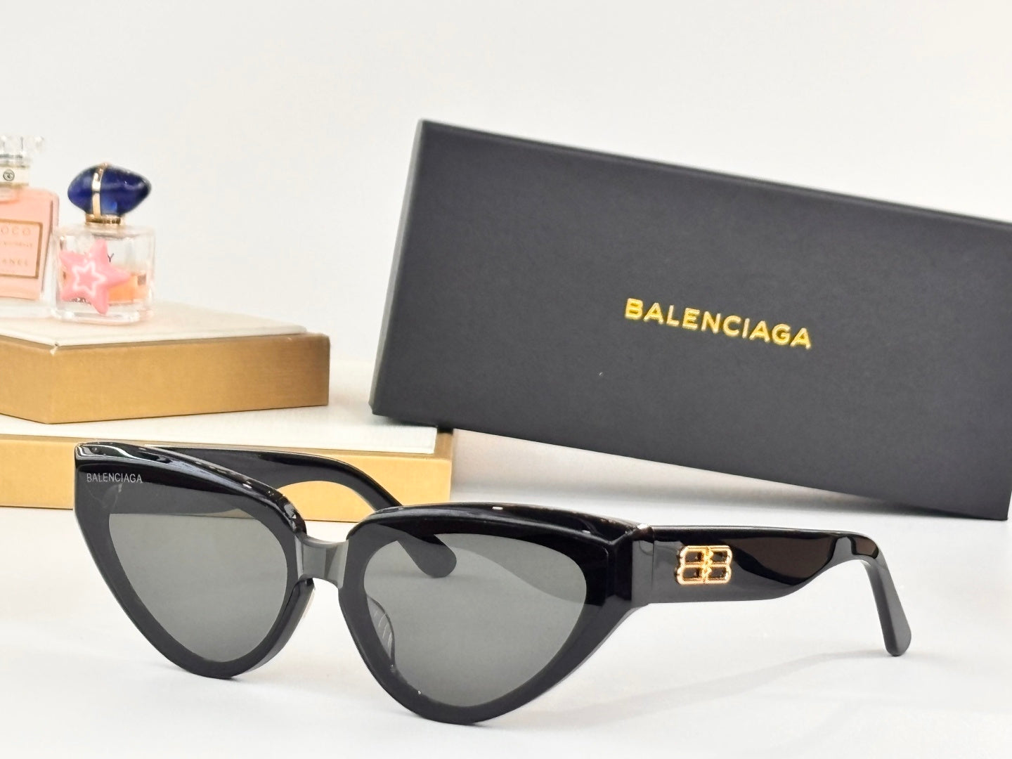 Black cat-eye sunglasses with gray-tinted lenses and gold B logo detail