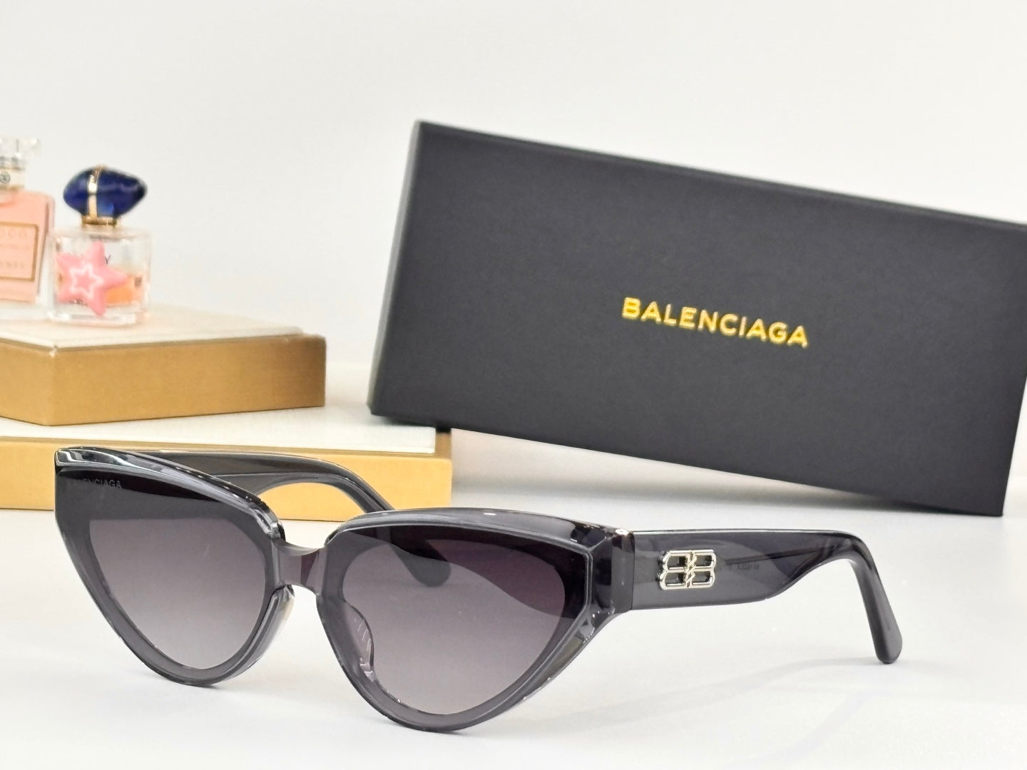 Black cat-eye sunglasses with dark lenses and gold B temple emblem