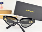 Black cat-eye sunglasses with gray lenses and gold B logo on temples