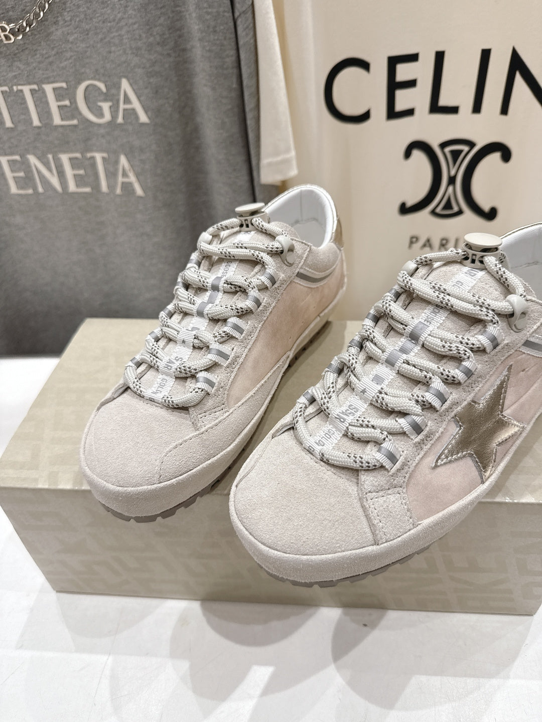 Golden Goose light gray lace-up sneakers with metallic star side detail, pair