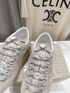 Golden Goose light gray lace-up sneakers close-up with patterned laces and round logo tag