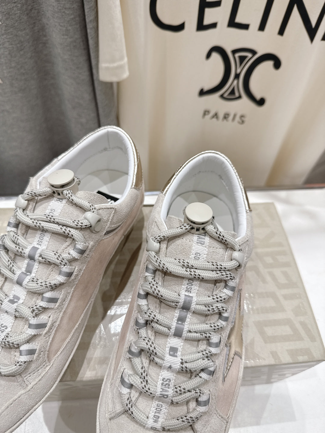 Golden Goose light gray lace-up sneakers close-up with patterned laces and round logo tag