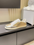 Low-top lace-up sneakers with white laces, gold mesh vamp, and white rubber sole