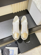 Low-top lace-up sneakers with white uppers and gold mesh panels, on white sole