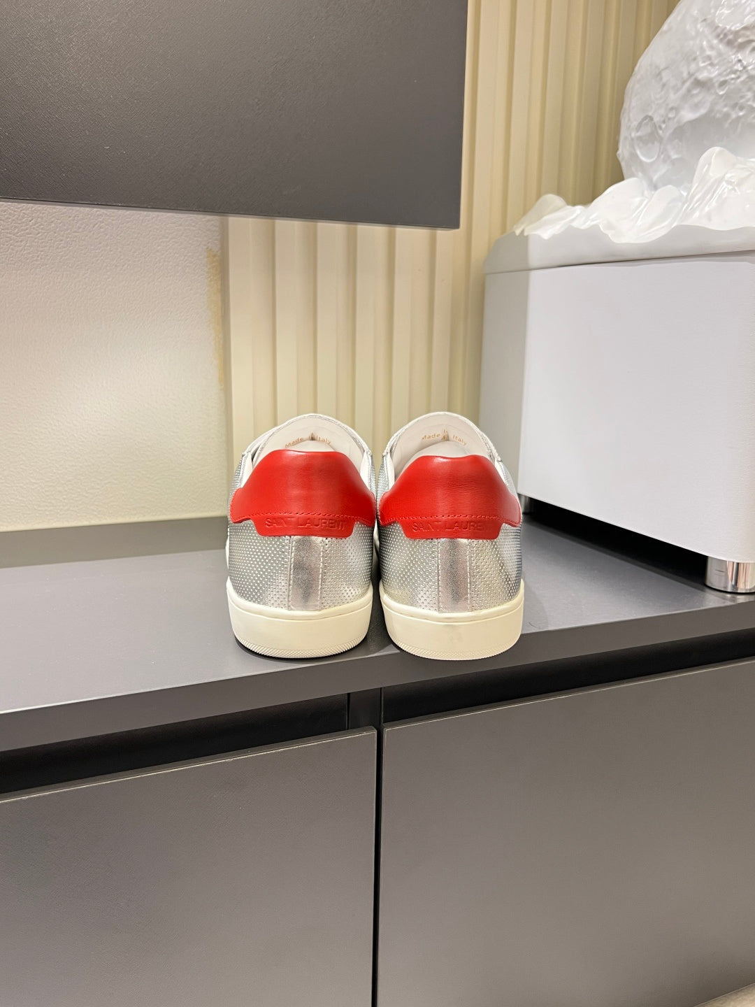 Unisex low-top sneakers back view, silver uppers with red heel and white sole