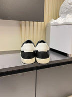 Unisex YSL sneakers rear view: dark uppers with white midsoles and lace-up openings.