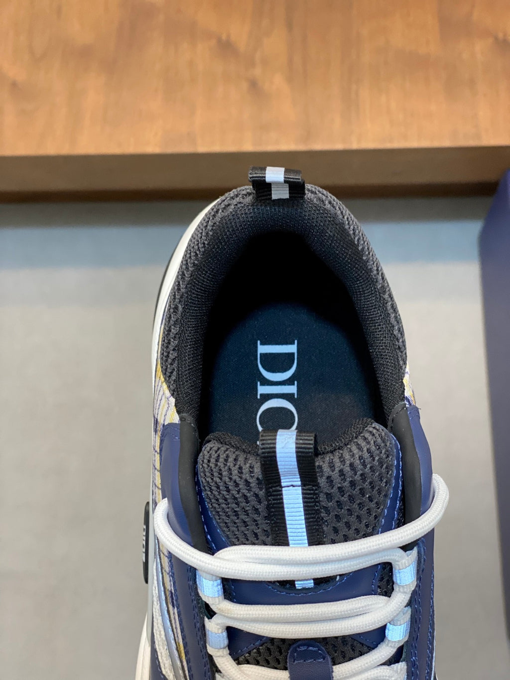 Dior unisex sneaker interior and tongue patch, dark lining with light blue stripe