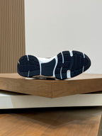 Outsole view of navy Dior sneakers, rubber tread with white midsole